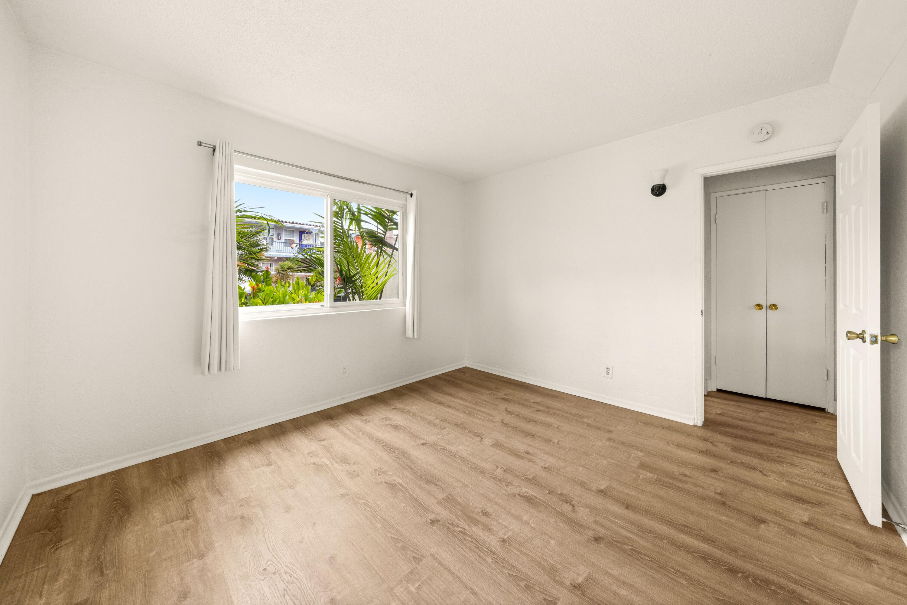 6597 Trigo Road Goleta, CA 93117 - Photo 12 of 20 an empty room with wooden floor and windows