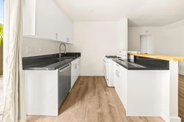 a kitchen with granite countertop a sink and a stove top oven