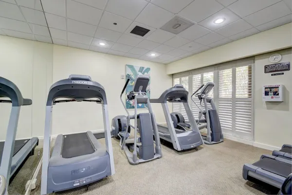 a gym room with lots of chairs and mirrors