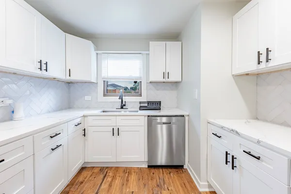 a kitchen with cabinets appliances and a window