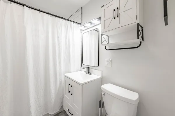 a bathroom with a sink a toilet and shower curtain