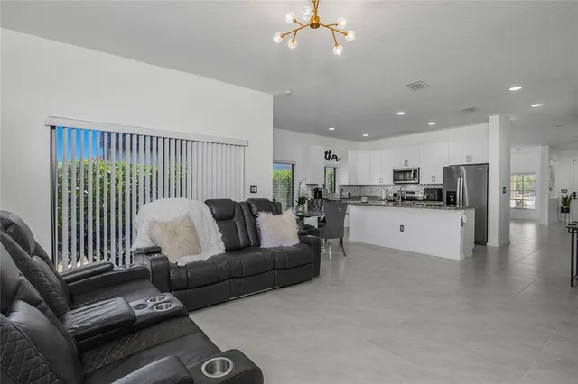 a living room with furniture and a view of kitchen