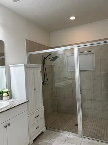 a bathroom with a shower and a sink mirror