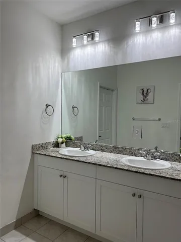 a bathroom with a granite countertop sink double and mirror
