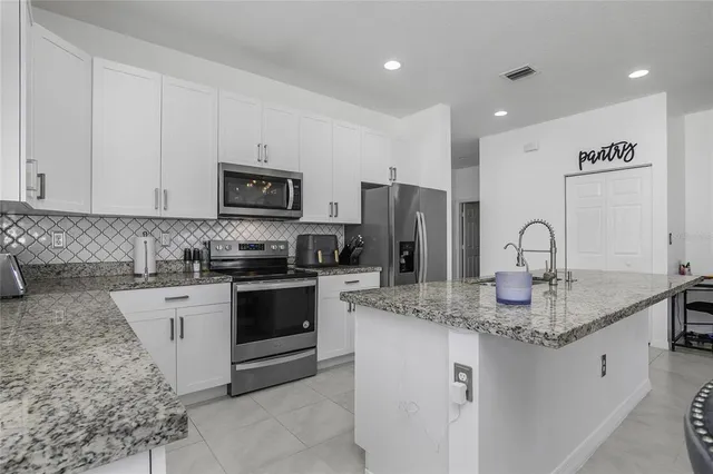 a kitchen with stainless steel appliances granite countertop a sink and cabinets