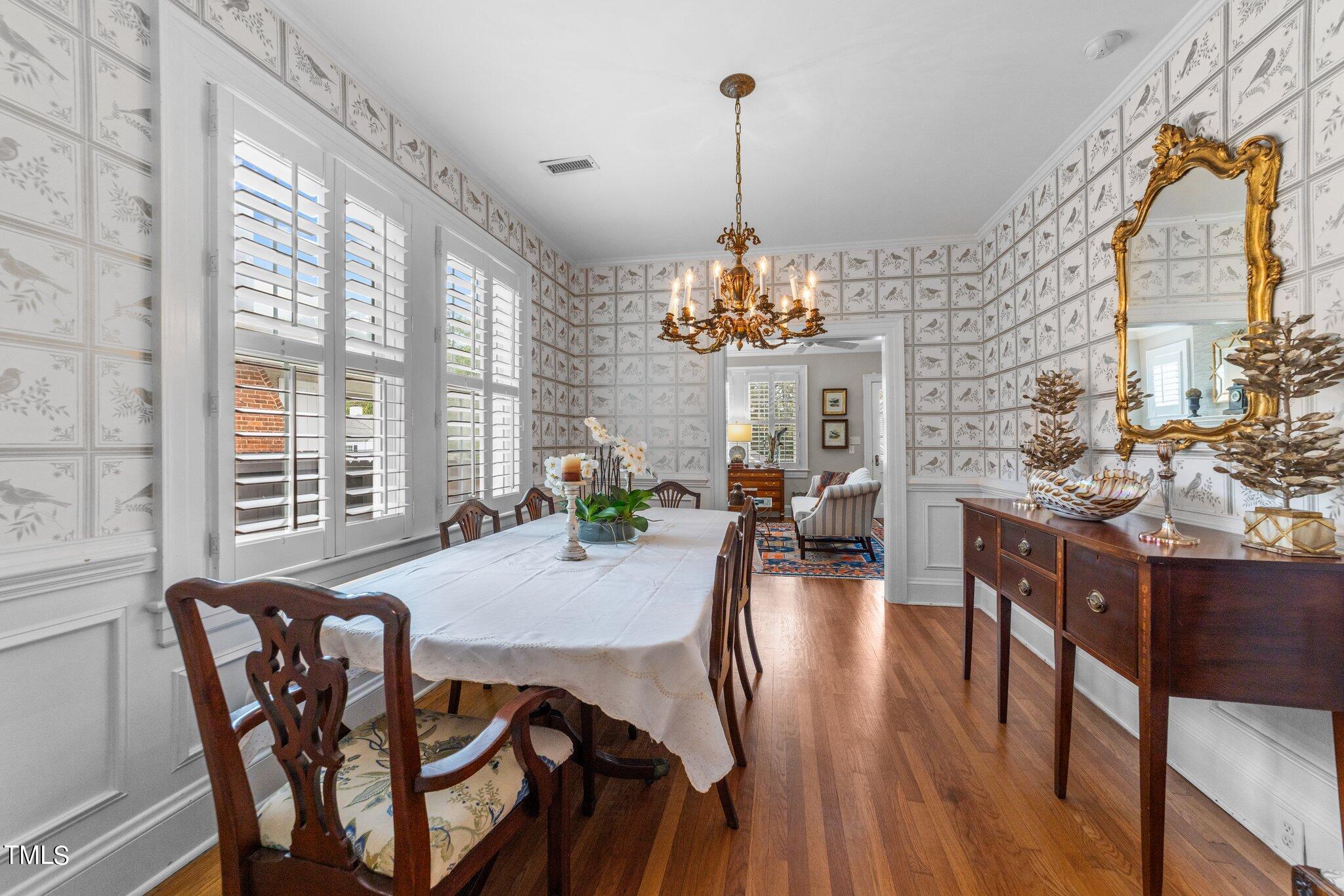 2219 Creston Road Raleigh, NC 27608 - Photo 11 of 45 a view of a dining room with furniture a chandelier and wooden floor
