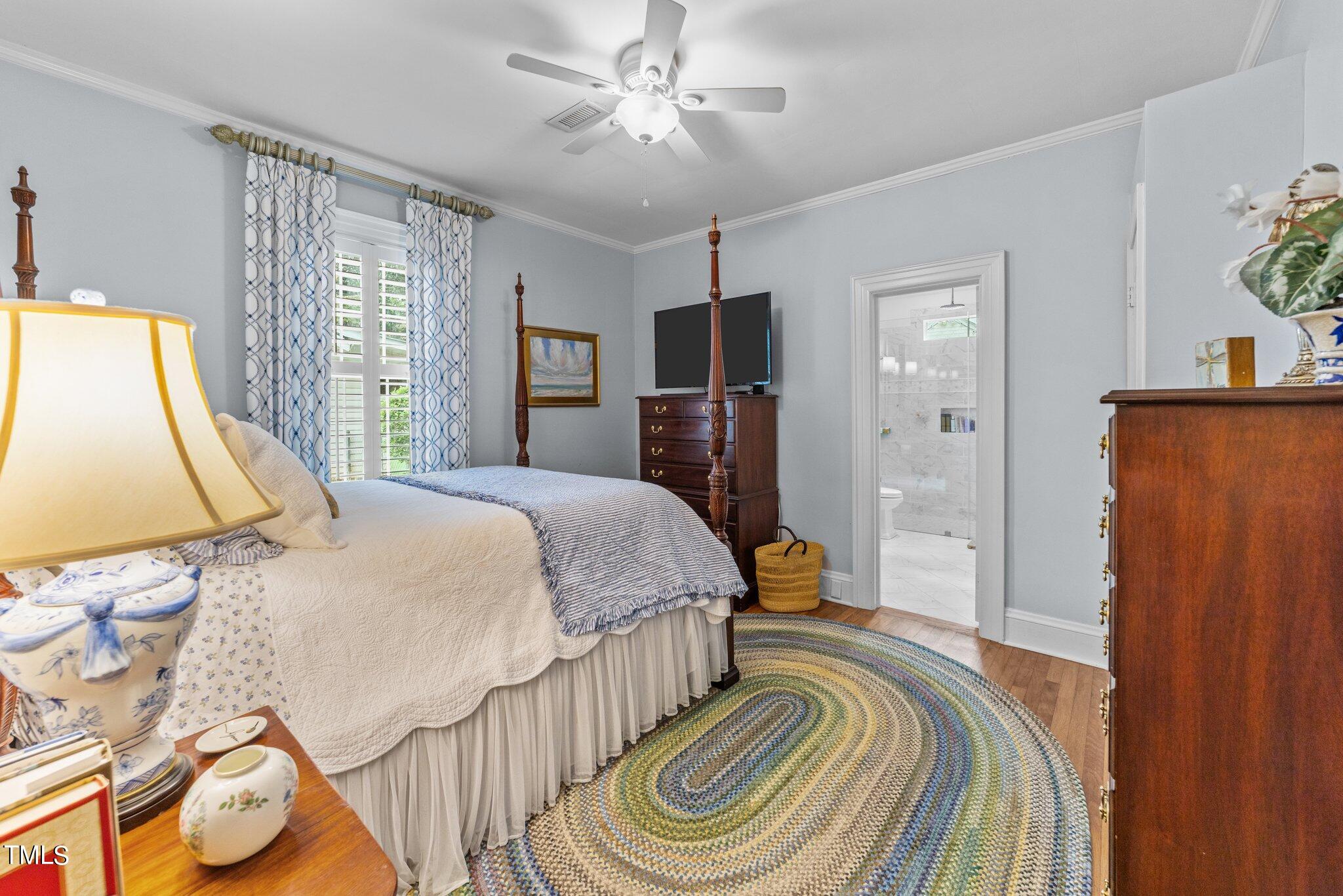 2219 Creston Road Raleigh, NC 27608 - Photo 13 of 45 a bedroom with a bed and a flat tv screen on dresser