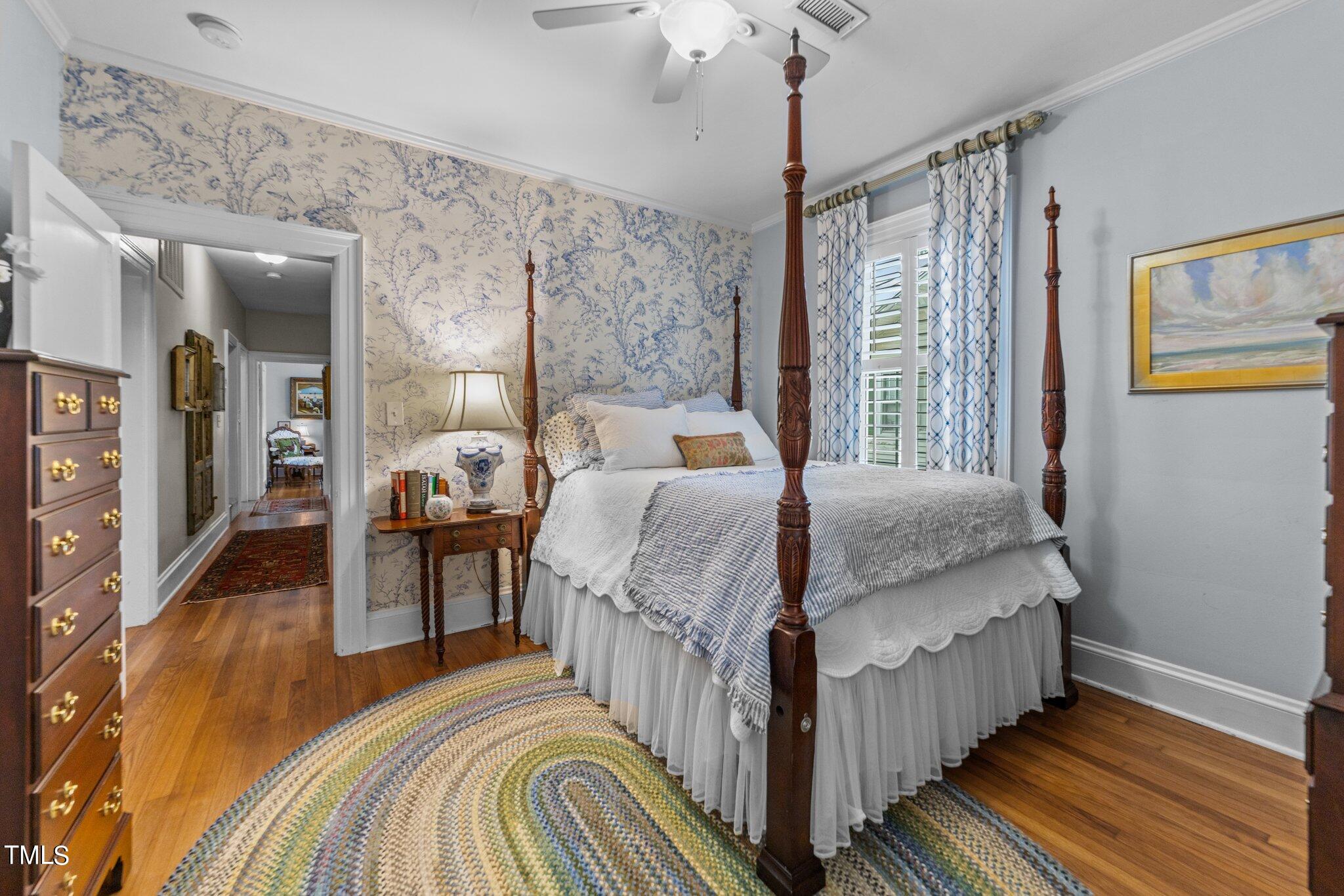 2219 Creston Road Raleigh, NC 27608 - Photo 14 of 45 a bedroom with a bed and wooden floor