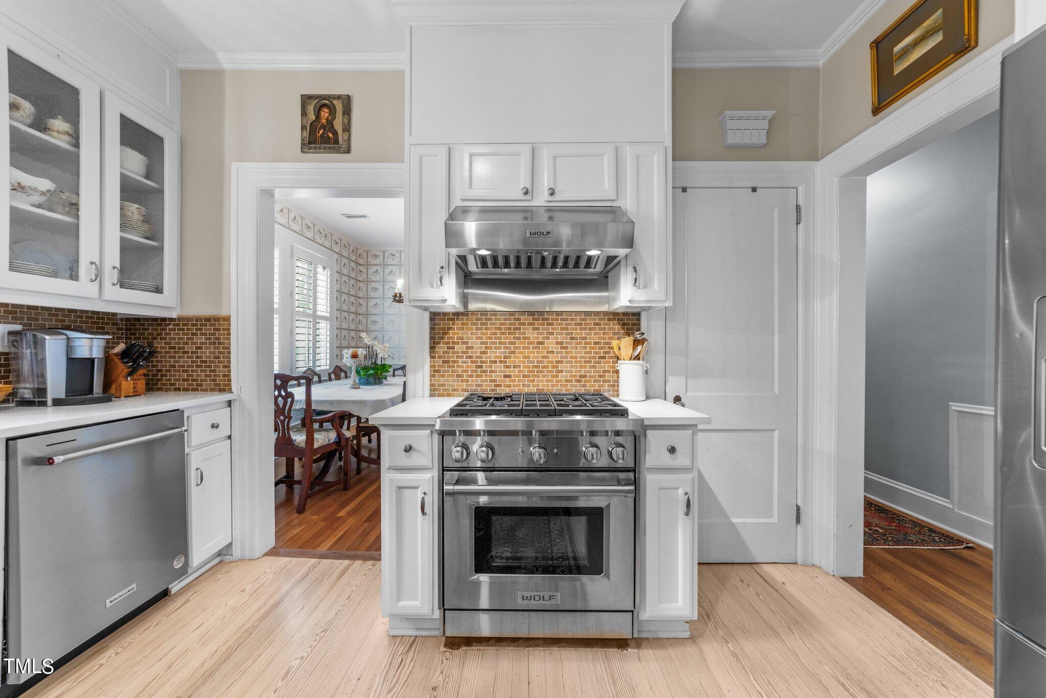 2219 Creston Road Raleigh, NC 27608 - Photo 18 of 45 a kitchen with stainless steel appliances granite countertop a stove and a refrigerator