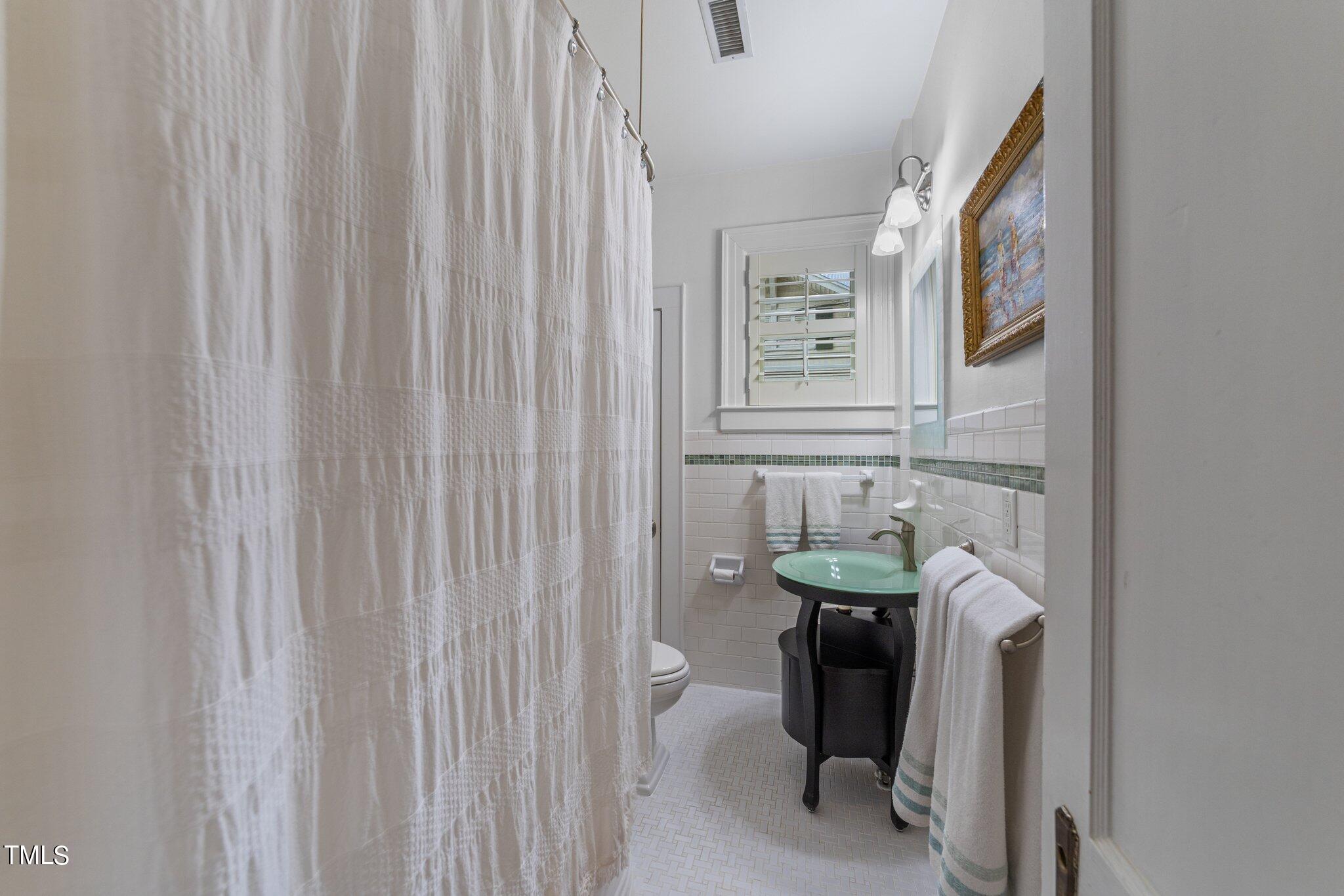 2219 Creston Road Raleigh, NC 27608 - Photo 20 of 45 a bathroom with a sink toilet and a mirror