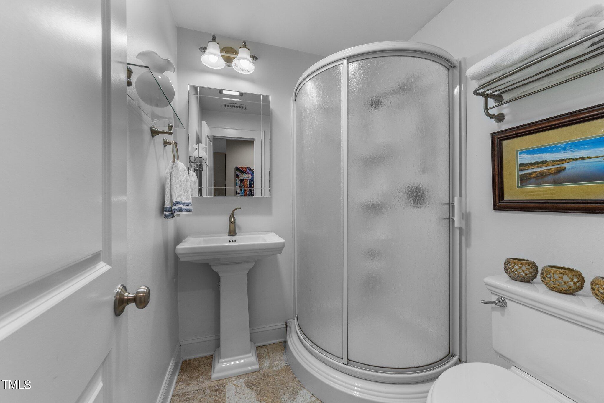 2219 Creston Road Raleigh, NC 27608 - Photo 22 of 45 a bathroom with a sink a toilet and shower