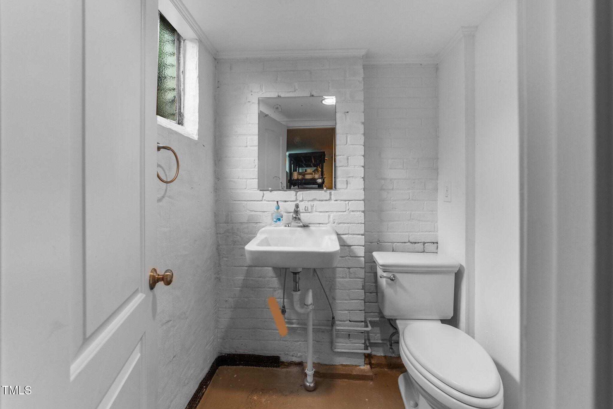 2219 Creston Road Raleigh, NC 27608 - Photo 32 of 45 a bathroom with a toilet a sink and mirror