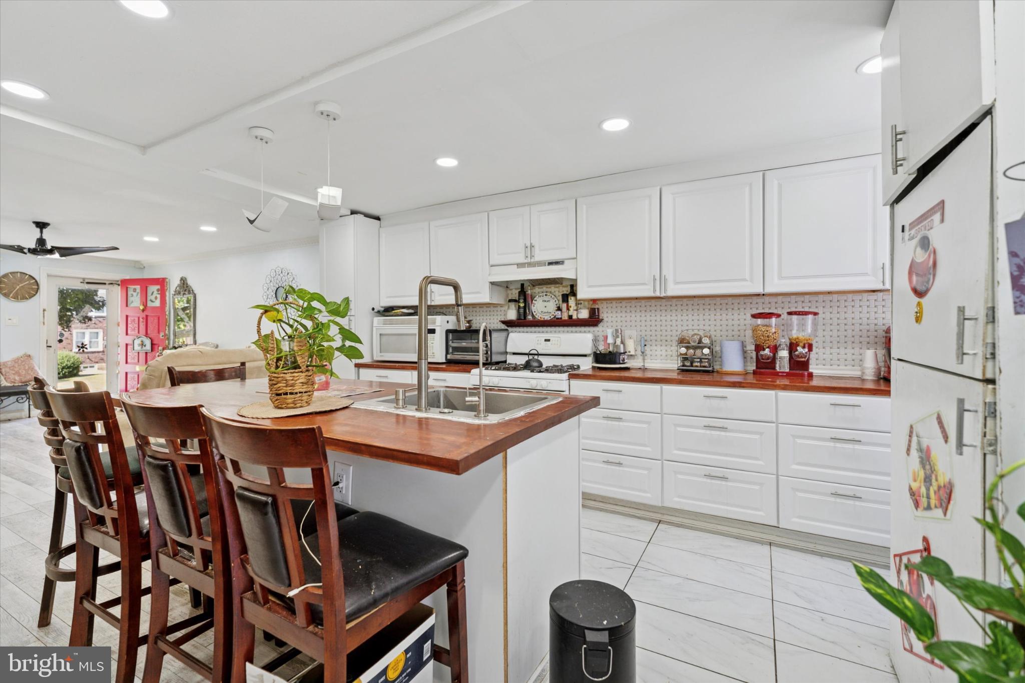 2548 Irvington Road Drexel Hill, PA 19026 - Photo 4 of 15 a kitchen with a table chairs and white cabinets