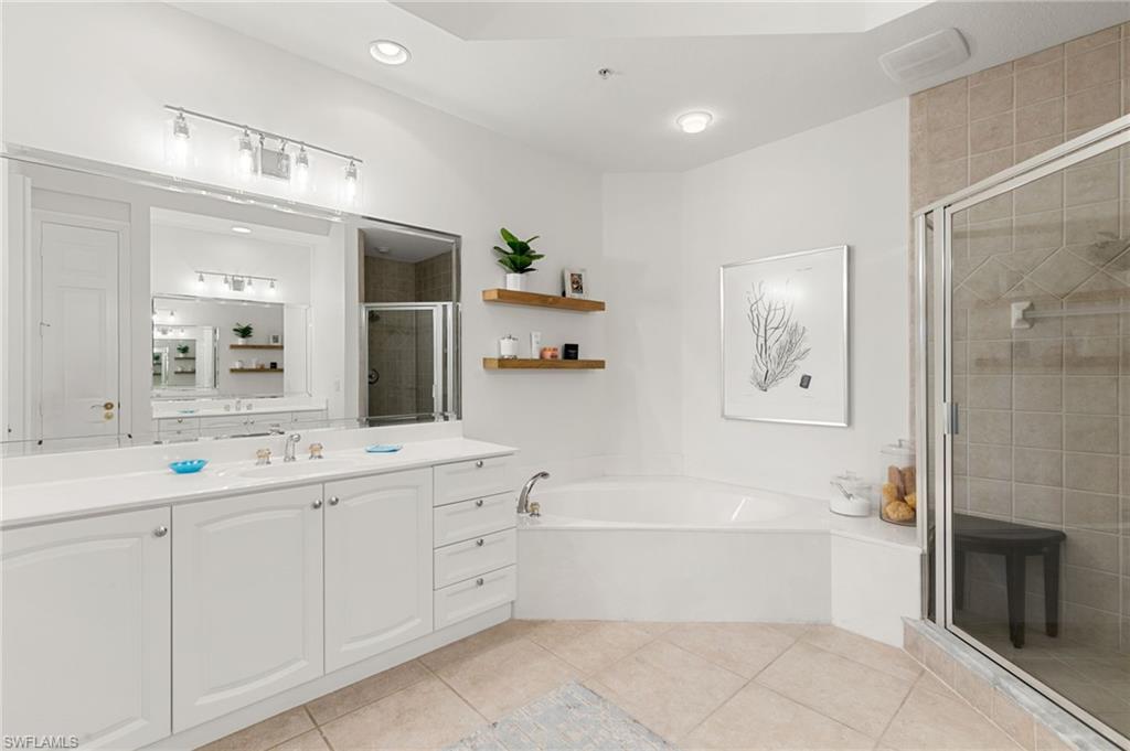 9082 Cascada Way, Unit 9102 Naples, FL 34114 - Photo 20 of 39 a bathroom with a bathtub a sink and a mirror