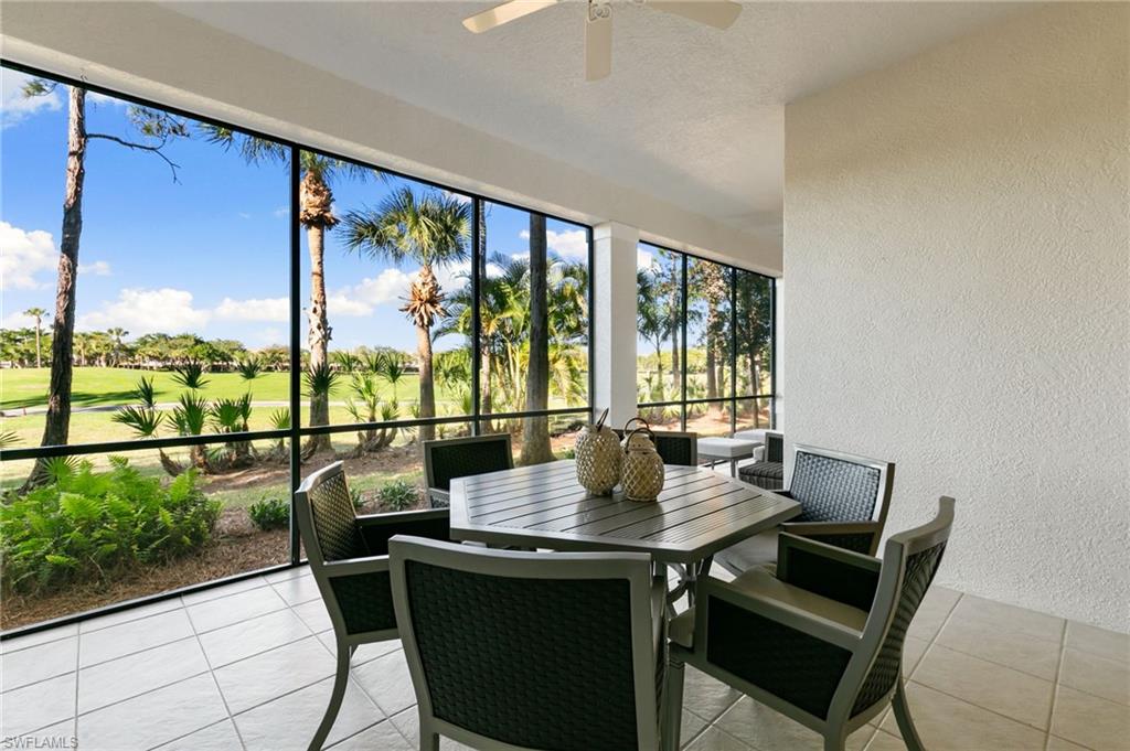 9082 Cascada Way, Unit 9102 Naples, FL 34114 - Photo 22 of 39 a view of a city from a dining room with large windows and wooden floor