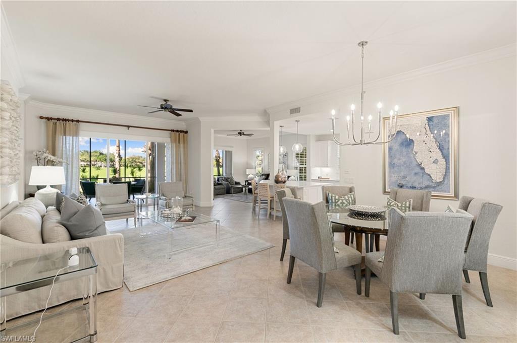 9082 Cascada Way, Unit 9102 Naples, FL 34114 - Photo 5 of 39 a dining room with furniture a chandelier and wooden floor