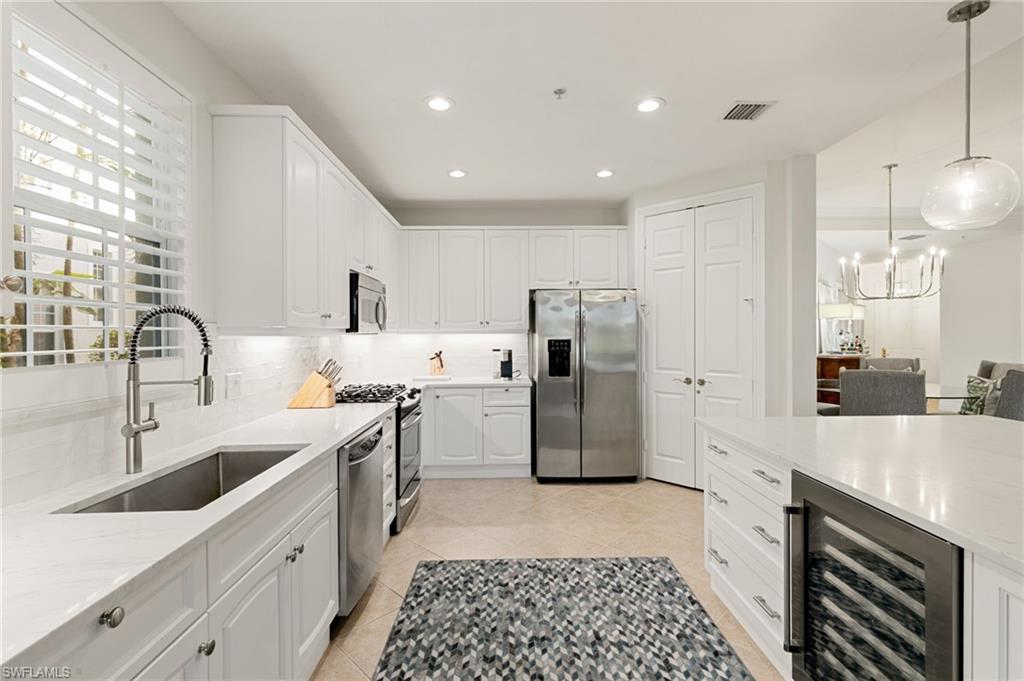 9082 Cascada Way, Unit 9102 Naples, FL 34114 - Photo 9 of 39 a large kitchen with a sink stainless steel appliances and cabinets