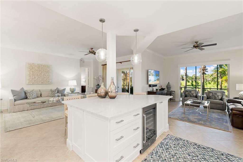 9082 Cascada Way, Unit 9102 Naples, FL 34114 - Photo 39 of 39 a large white kitchen with a stove a sink a dining table and chairs
