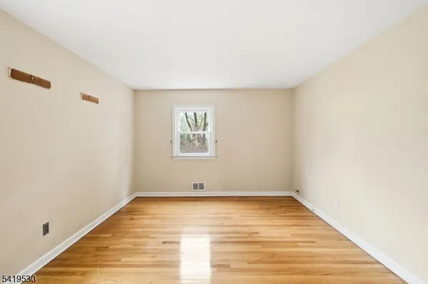 a view of room with window and wooden floor