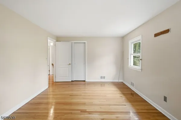 a view of room with window and wooden floor