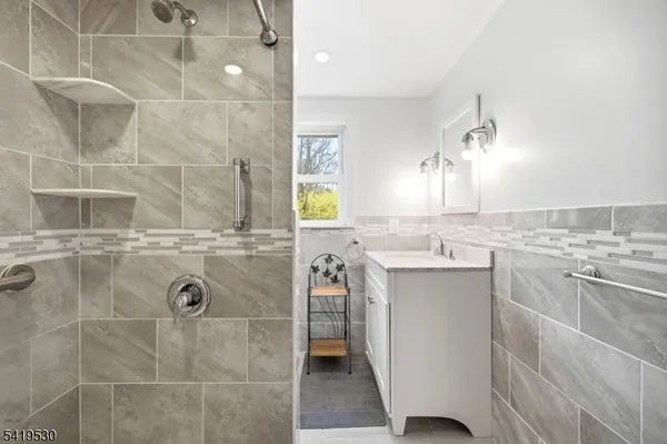a bathroom with a granite countertop sink a toilet and shower