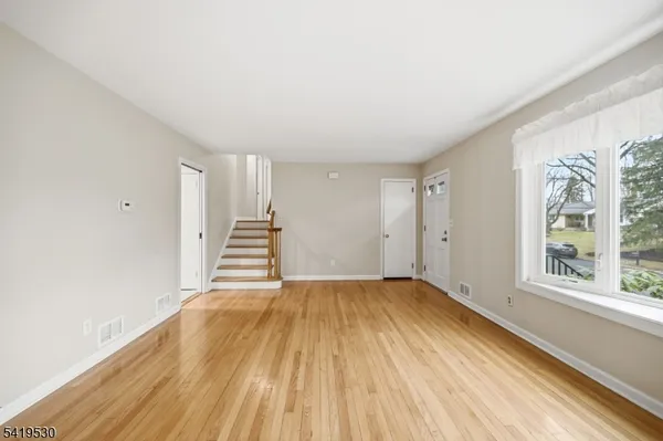 a view of a room with wooden floor and white walls