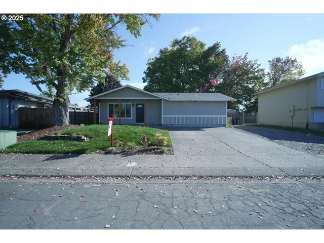 a front view of a house with a yard and potted plants