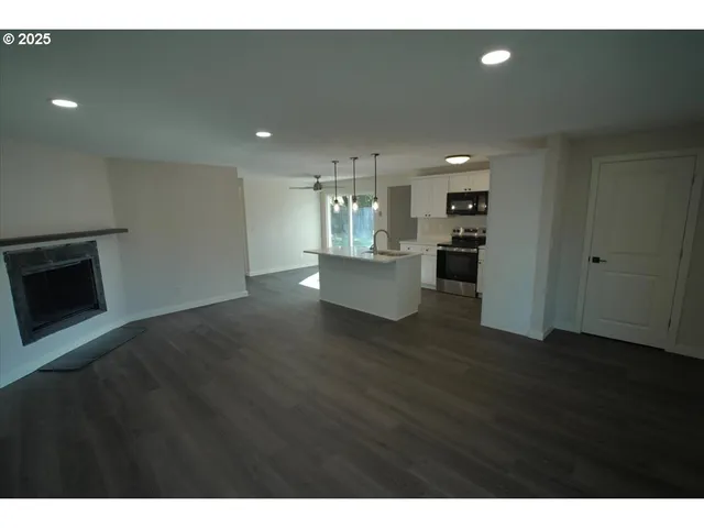 a view of a living room kitchen with furniture and wooden floor