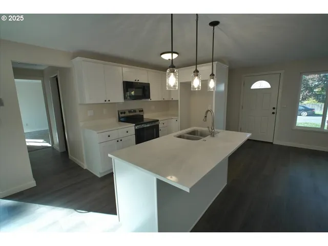 a kitchen with a sink a counter space and a refrigerator