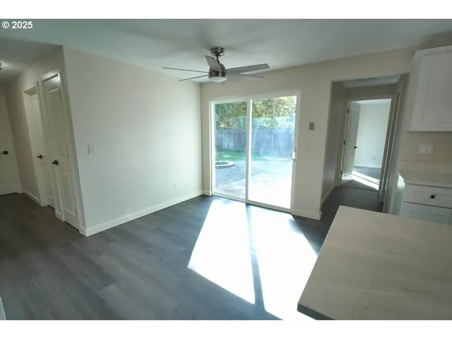 a living room with hardwood floor and a ceiling fan