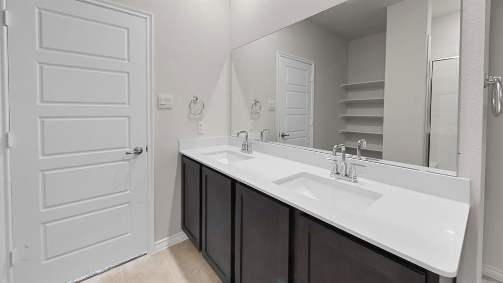 412 Carthage Street Caddo Mills, TX 75135 - Photo 3 of 32 Double vanity featuring dark wood-finish cabinetry and white countertops