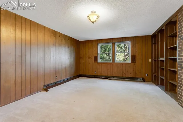 an empty room with windows lake and mountain view