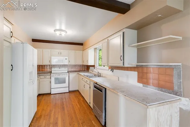 a kitchen with white cabinets and white appliances