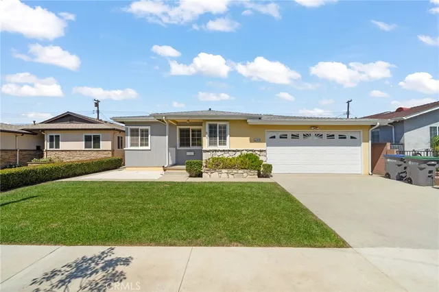 a front view of a house with a yard and potted plants