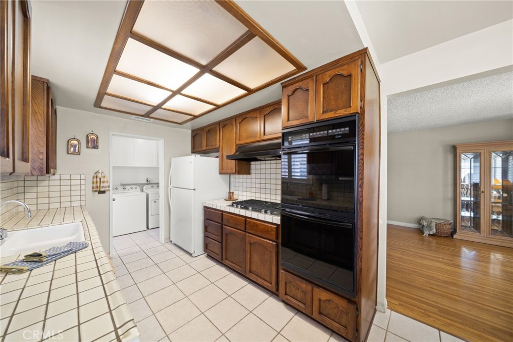 513 West Shadwell Street Carson, CA 90745 - Photo 7 of 23 a kitchen with white cabinets and appliances