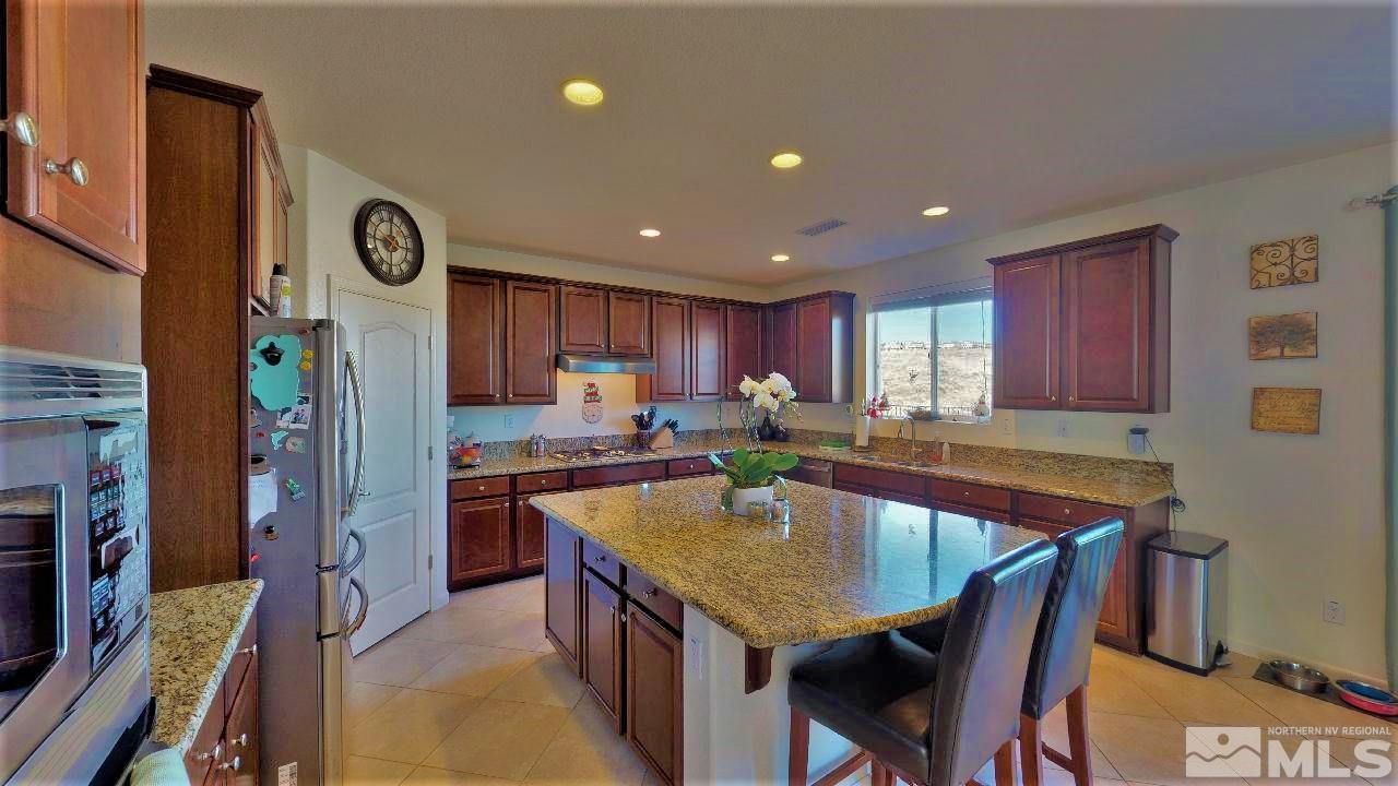 2248 Isabella Drive Sparks, NV 89434 - Photo 4 of 22 a kitchen with stainless steel appliances granite countertop a kitchen island a stove a refrigerator and a dining table