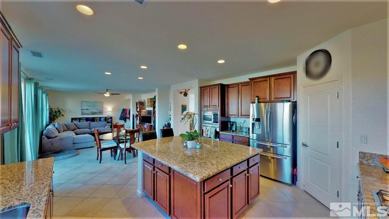 2248 Isabella Drive Sparks, NV 89434 - Photo 5 of 22 a kitchen with stainless steel appliances granite countertop a table chairs and a refrigerator