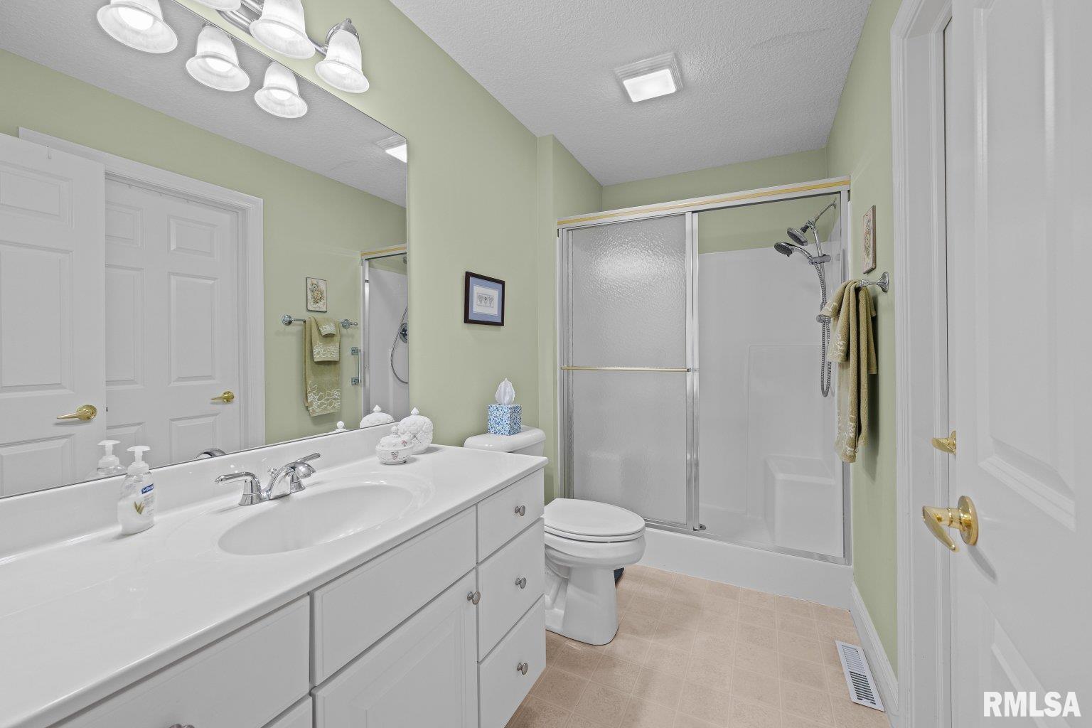 451 Celeste Circle Blue Grass, IA 52726 - Photo 18 of 35 a bathroom with a sink a toilet a mirror and shower