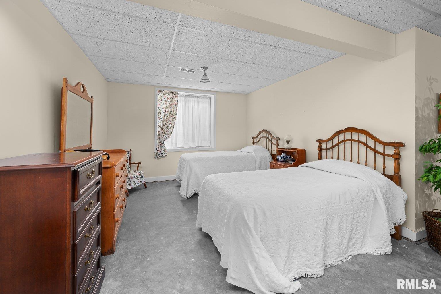 451 Celeste Circle Blue Grass, IA 52726 - Photo 27 of 35 a spacious bedroom with two beds and a chandelier