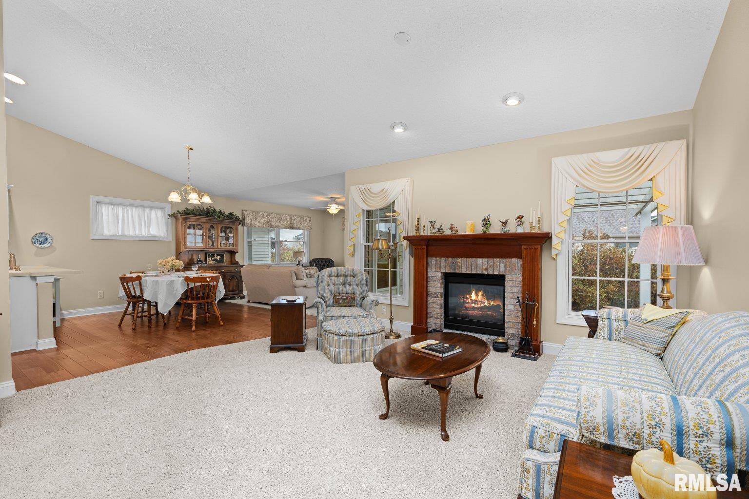 451 Celeste Circle Blue Grass, IA 52726 - Photo 8 of 35 a living room with furniture a fireplace and a dining table