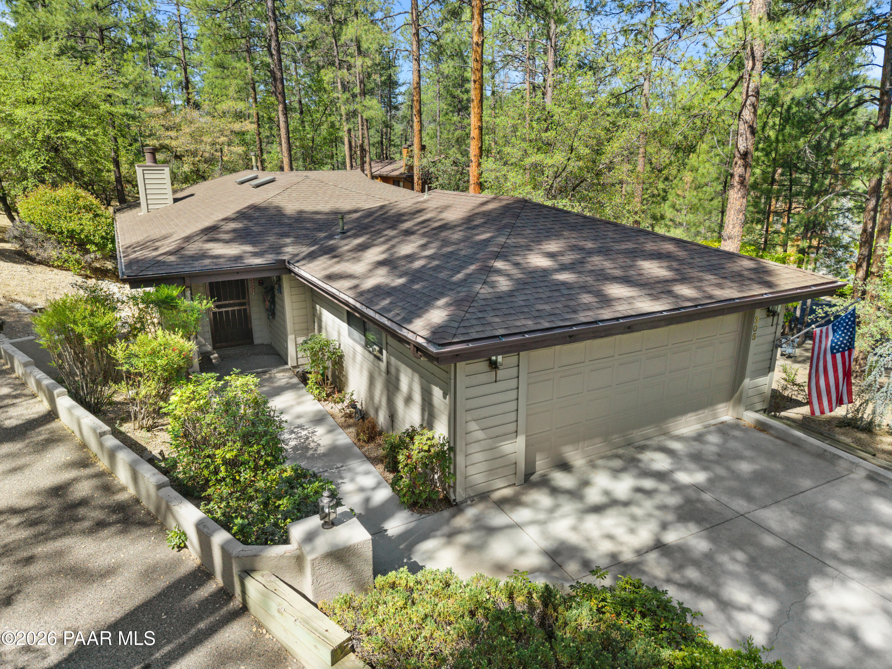 305 Ridge Court Prescott, AZ 86303 - Photo 2 of 35 a backyard of a house with large trees and plants
