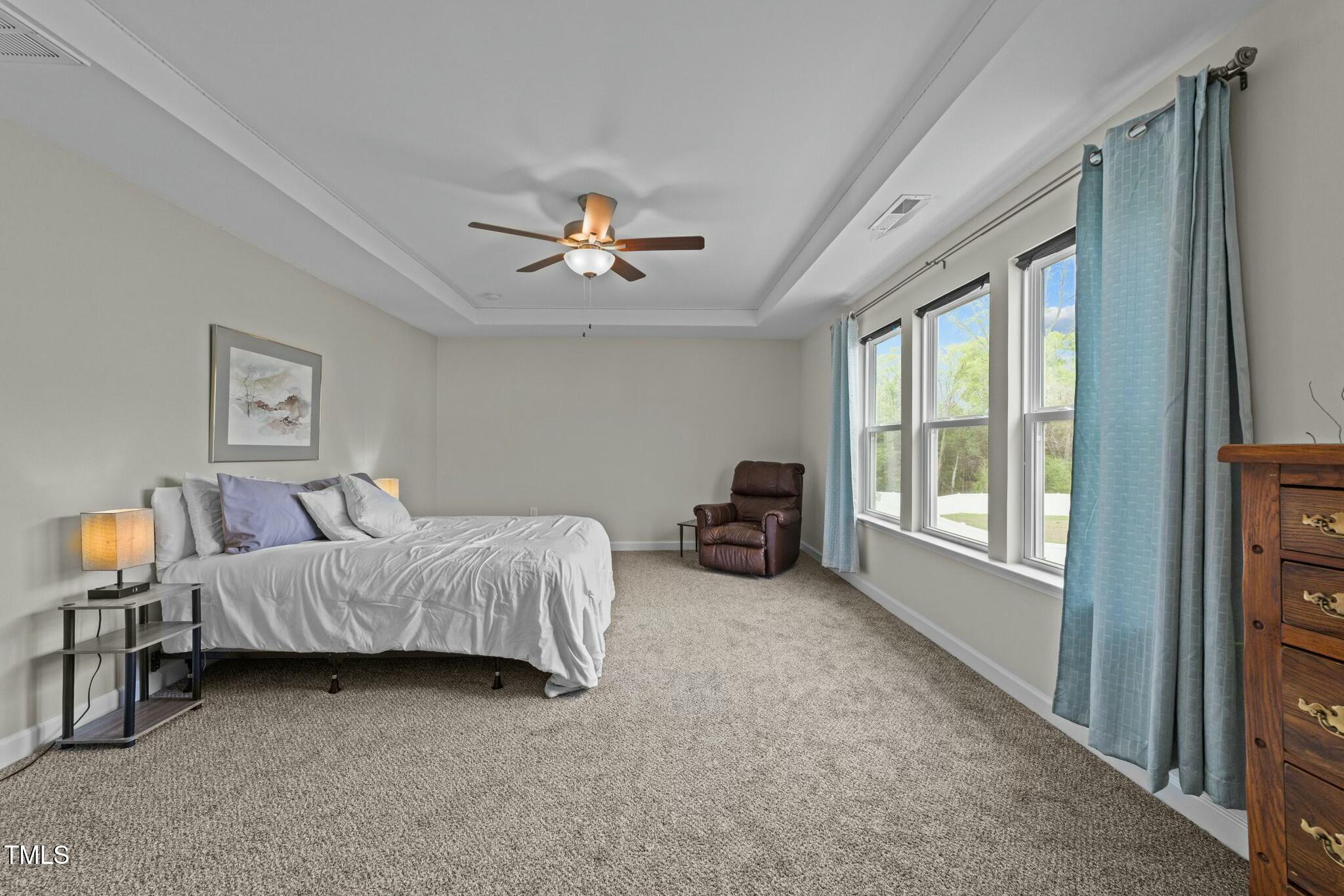 118 Lockhaven Drive Garner, NC 27529 - Photo 22 of 56 a spacious bedroom with a bed and a chandelier