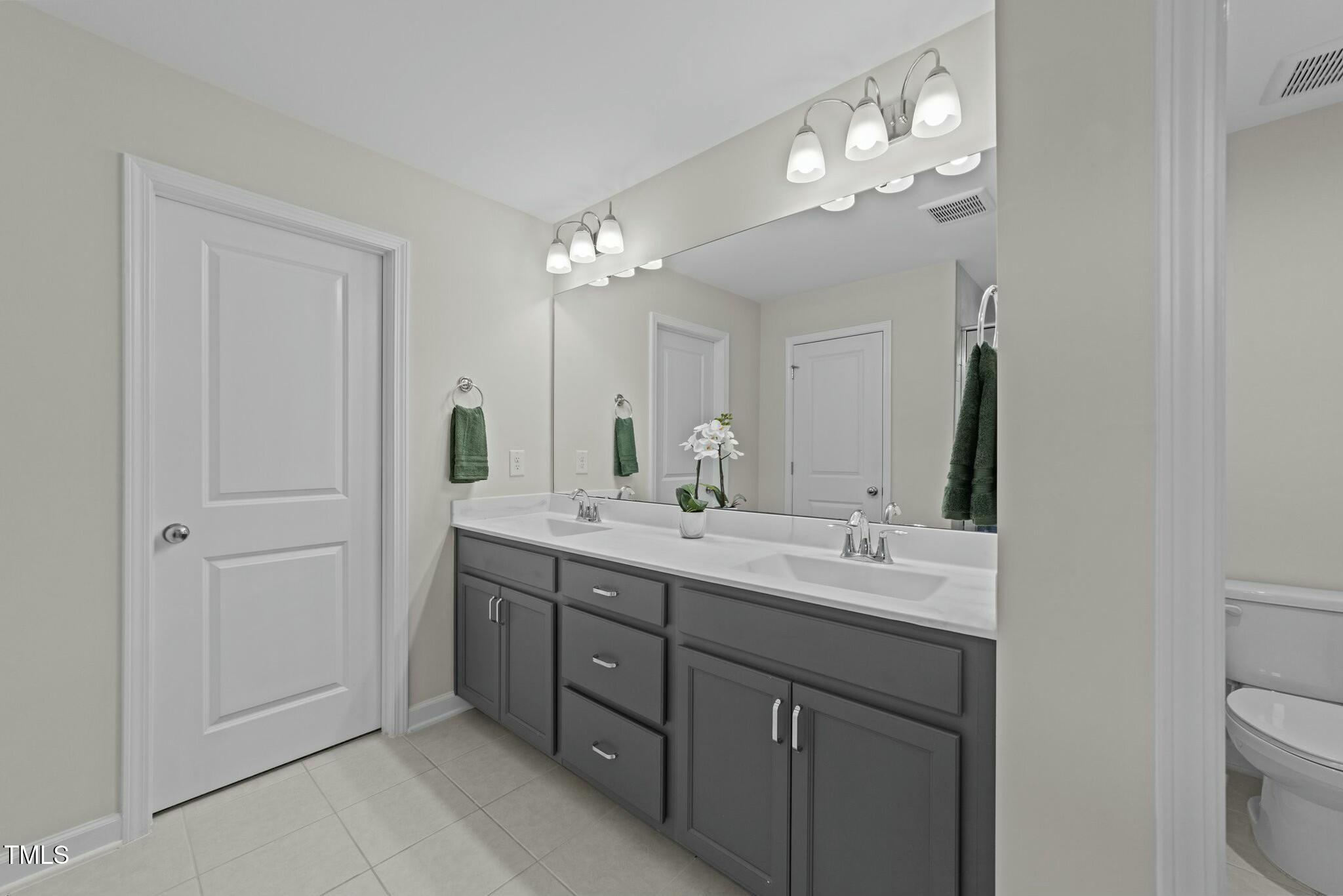 118 Lockhaven Drive Garner, NC 27529 - Photo 24 of 56 a bathroom with a double vanity sink and a mirror