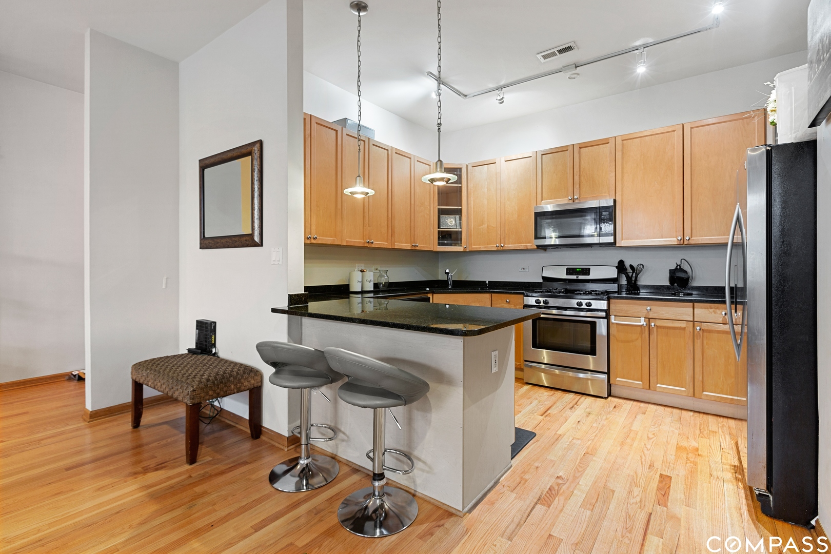 2136 West Monroe Street, Unit 204 Chicago, IL 60612 - Photo 9 of 15 a kitchen with stainless steel appliances kitchen island granite countertop a stove a sink and a refrigerator