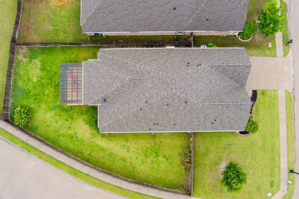1501 Calcot Lane Forney, TX 75126 - Photo 31 of 34 Overhead property view featuring a gabled roofline, expansive green lawn areas, a fenced backyard, an attached screened enclosure, and a paved driveway
