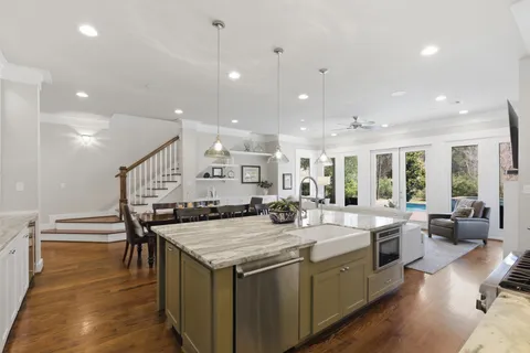 a large kitchen with kitchen island a large island a sink a stove and a center island