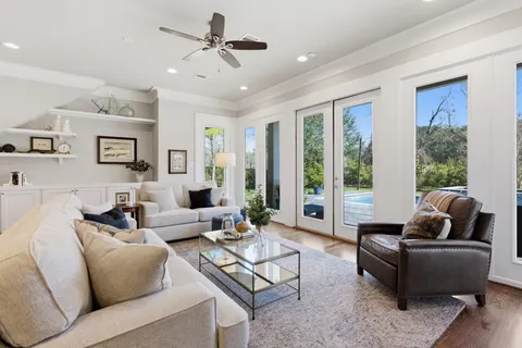 a living room with furniture and large windows
