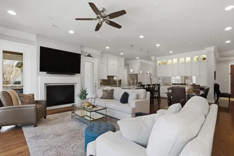 a living room with furniture a fireplace and a flat screen tv