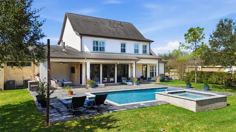a view of a house with swimming pool and sitting area