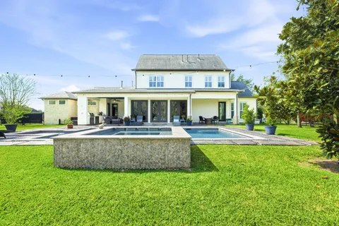 a view of a house with swimming pool and a yard